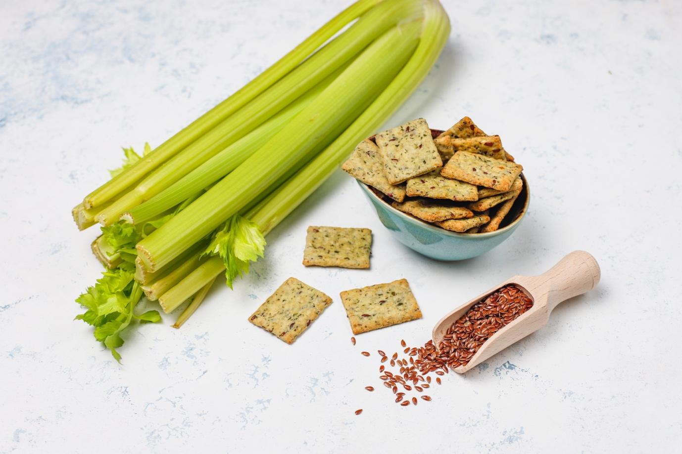 A bowl of crackers and a spoon of flax seeds

Description automatically generated